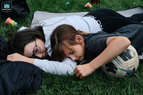This candid photograph captures two sisters enjoying a playful moment on the ground after a game of football in their family home in North Yorkshire, England.